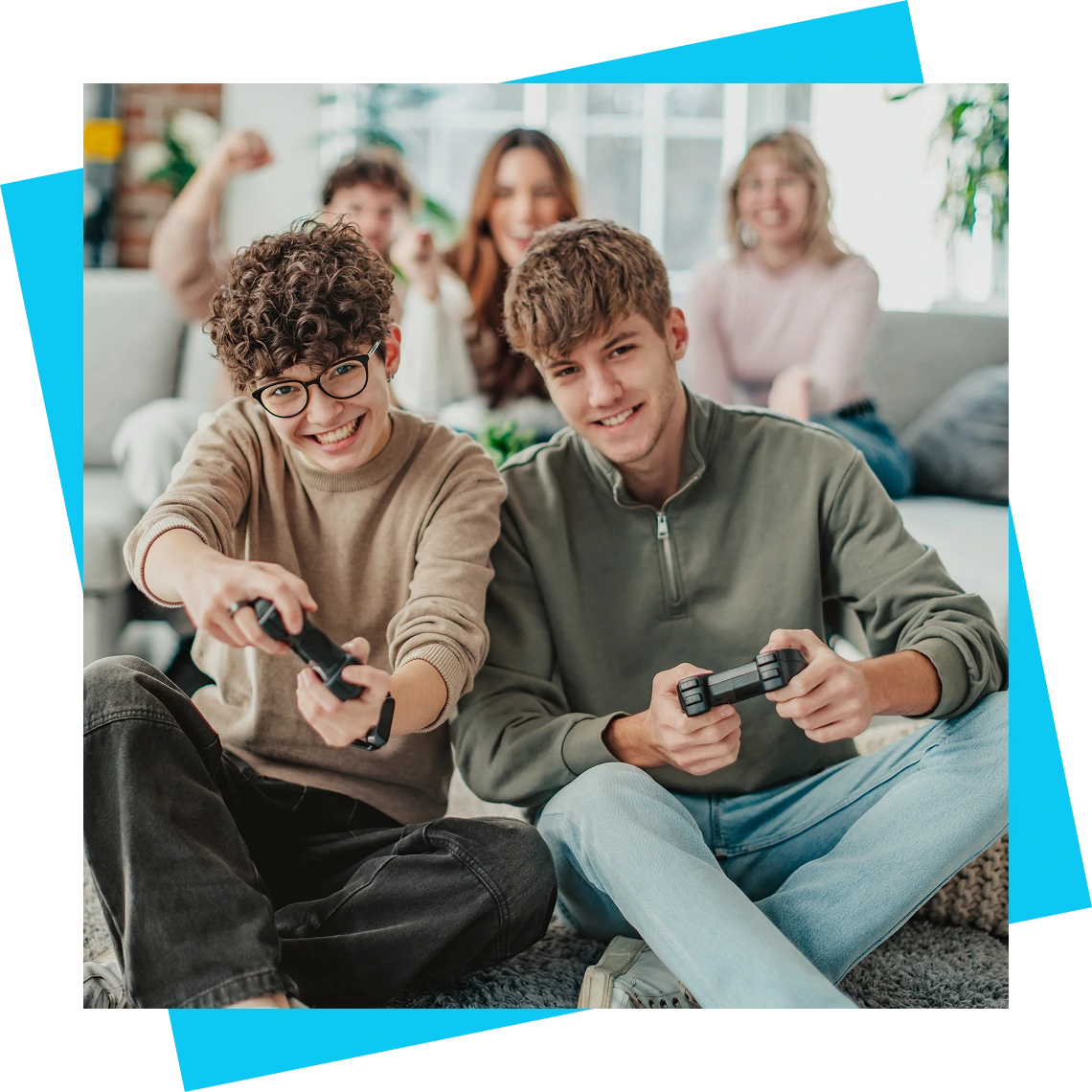 Teens playing video games with friends cheering.